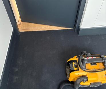 Vue générale de la cage d'escalier habillée de tapis anthracite